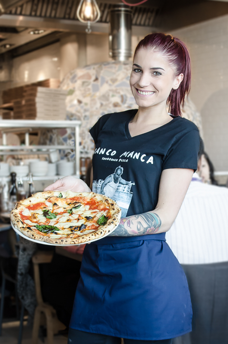 waitress showing a beautiful margherita pizza