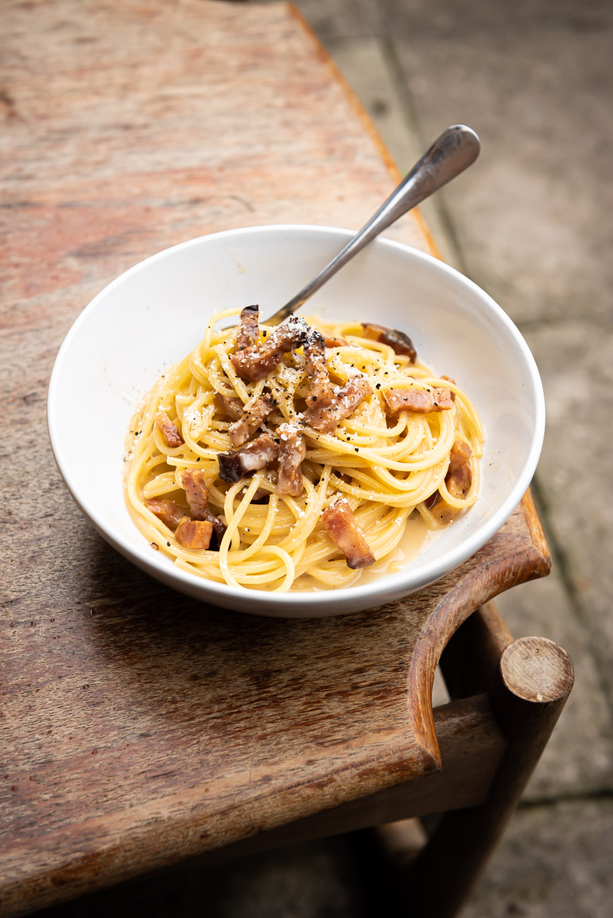 Authentic Spaghetti alla Carbonara pasta plate on wooden table