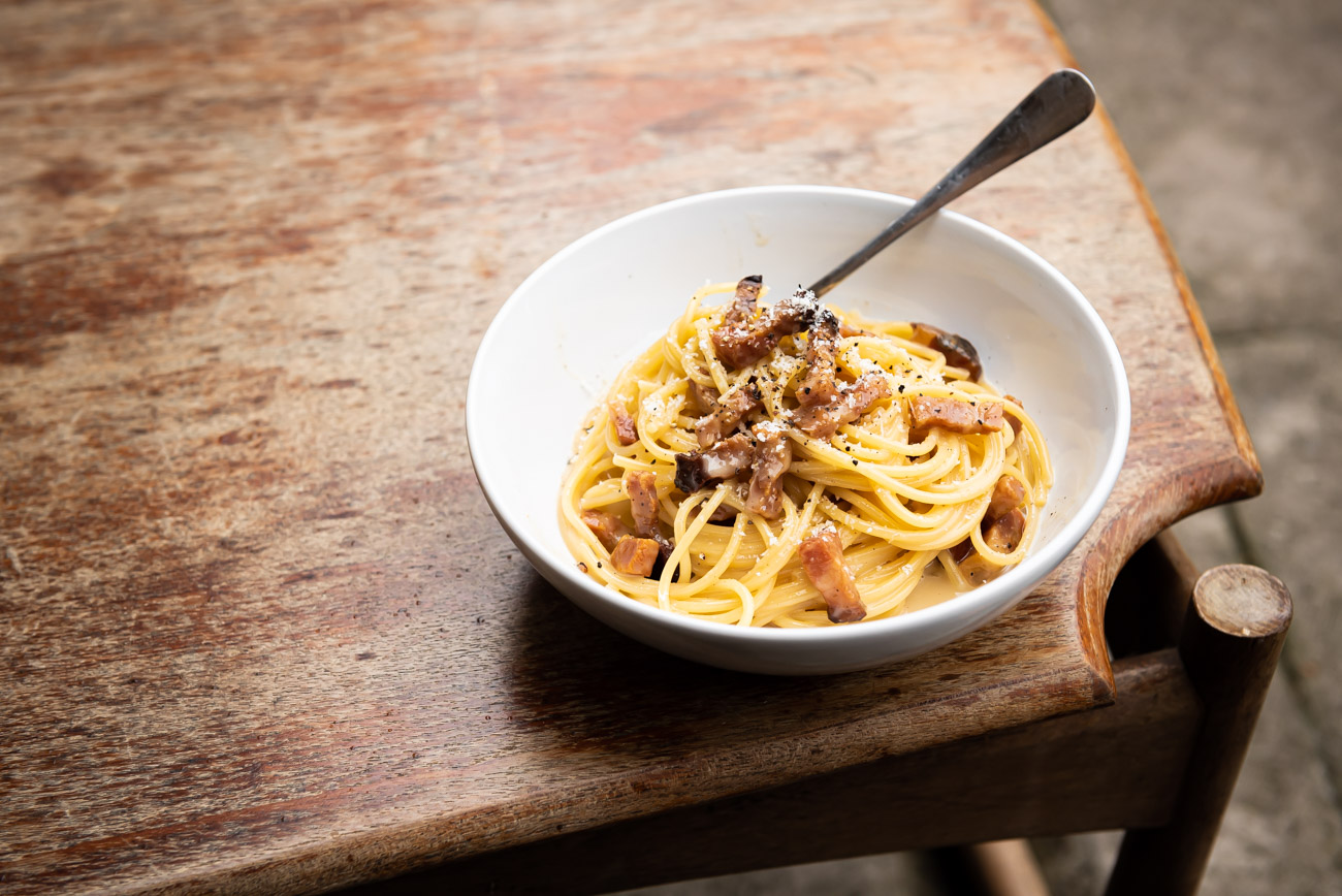 Authentic Spaghetti alla Carbonara plate on wooden table