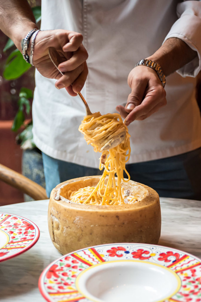 Chef rolling spaghetti alla carbonara with a fork