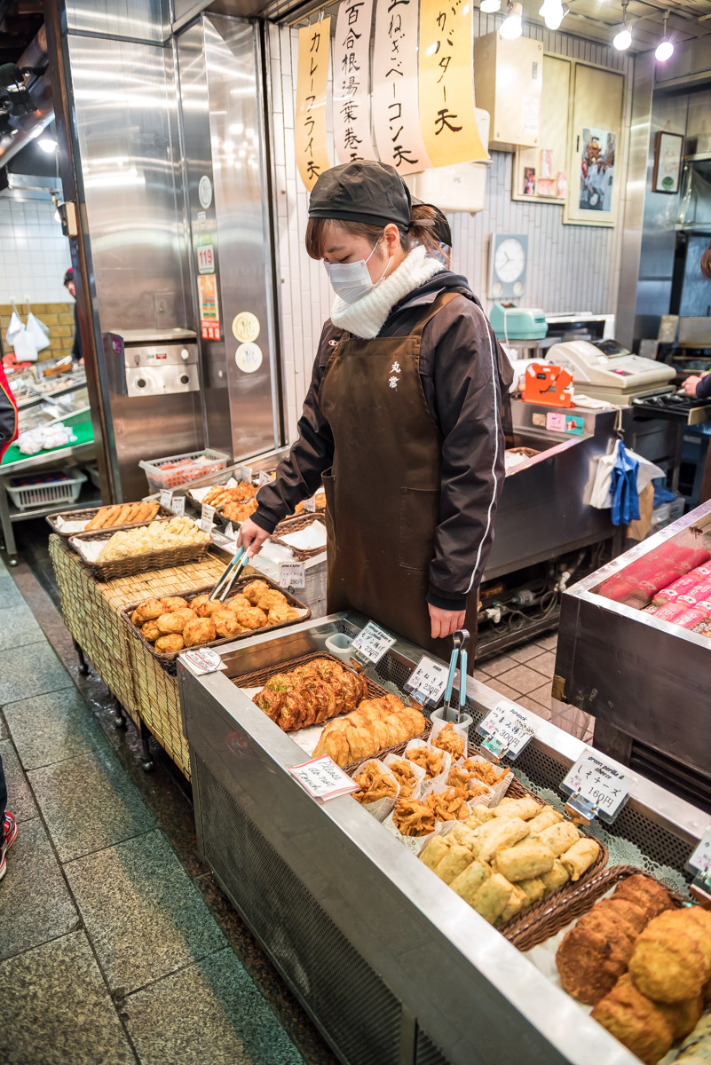 lady selling street food in Tsukiji market in Tokyo