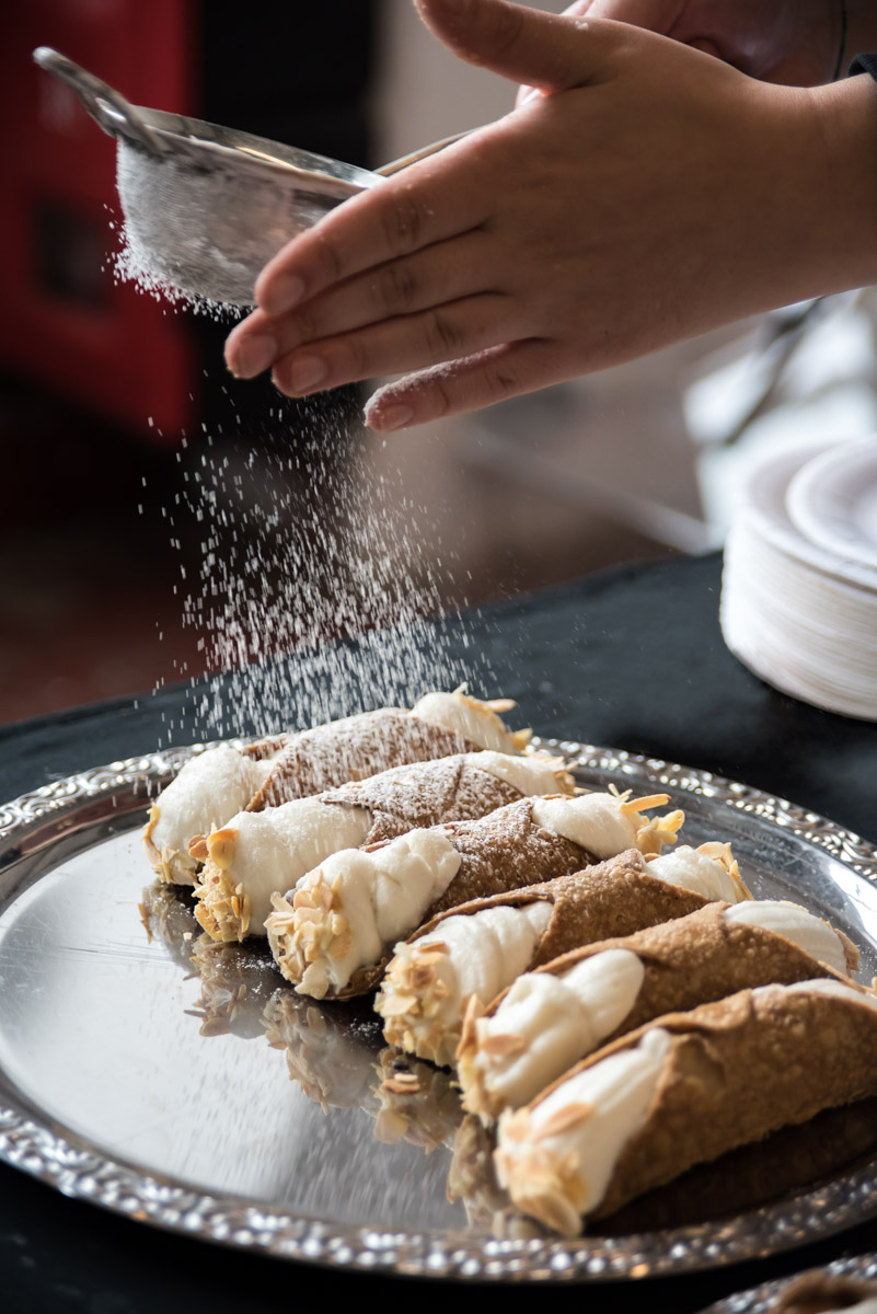 tips for street food photography - sprinkling icing sugar on cannoli