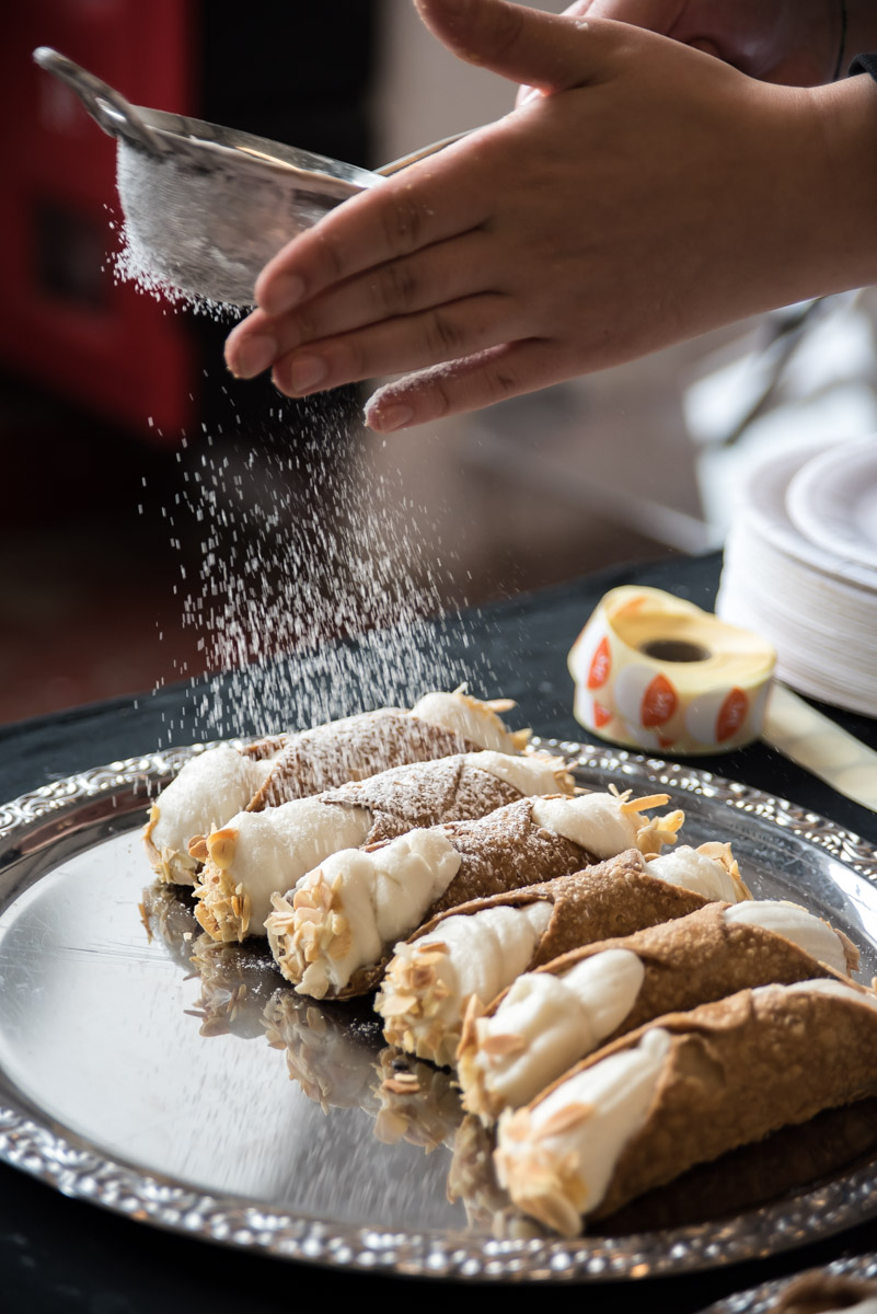 tips for street food photography - sprinkling icing sugar on cannoli