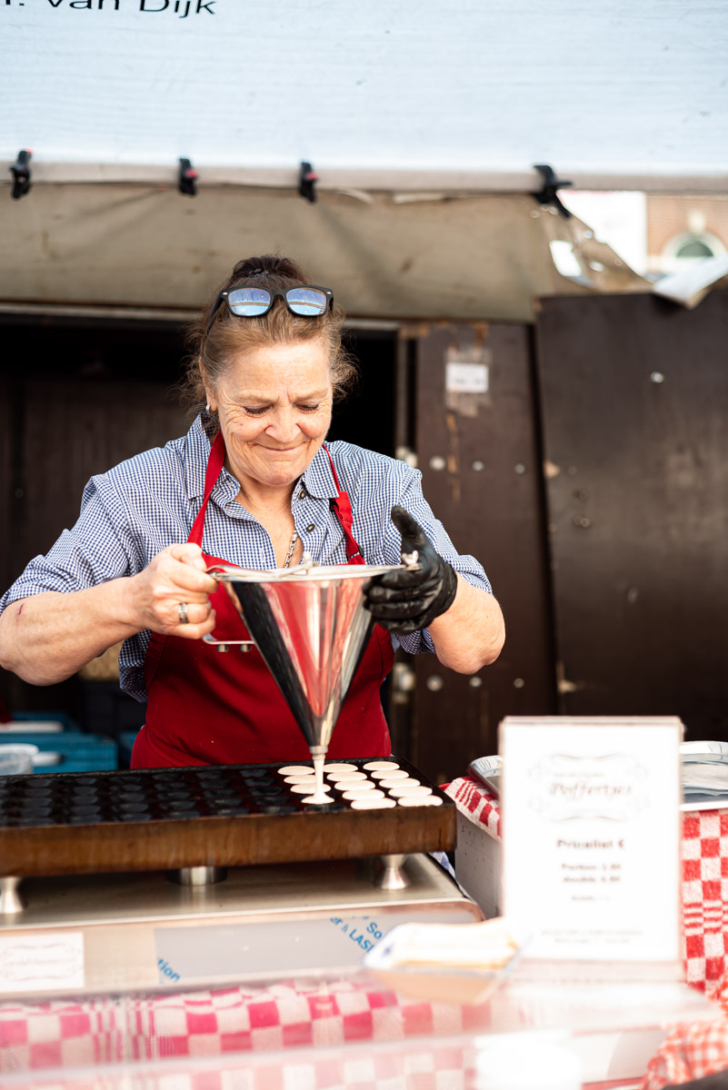 tips for street food photography - a vendor pouring the batter for Dutch pancakes