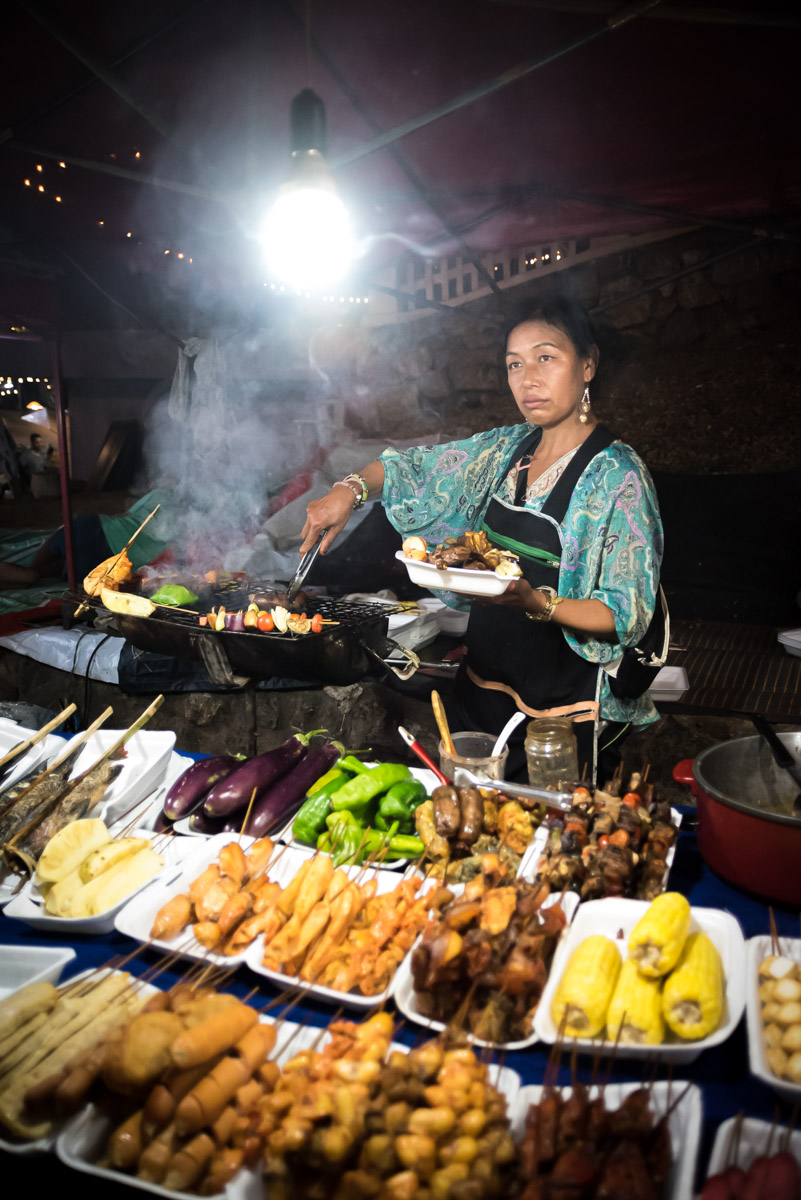tips for street food photography - vendor serving skewers of meat and vegetables